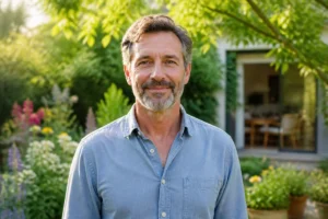 Adulte serein souriant dans un jardin lumineux, incarnant l’apaisement après une période de stress chronique